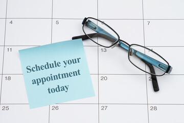 Eye exam doctor appointment with glasses and sticky note on a calendar