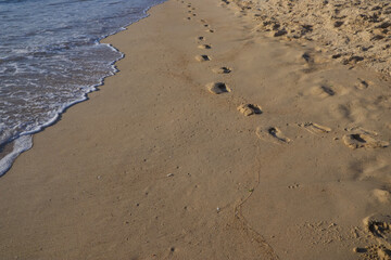 human footprints on the beach shore with the golden sand in France