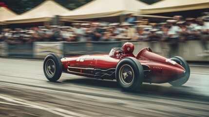 Vintage racing cars roaring past cheering spectators on a historic track