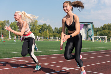 Two athlete young woman runnner at the stadium outdoors