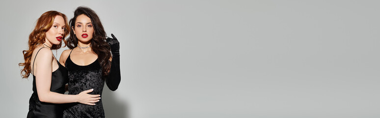 Two women, a loving lesbian couple, elegantly dressed in black, pose happily for a picture.