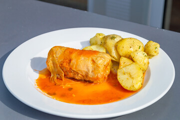 Stuffed cabbage in tomato sauce with potatoes.