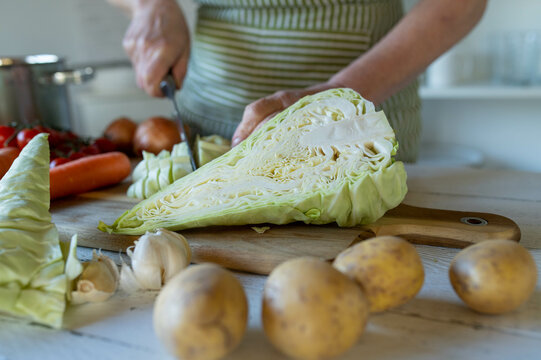 Cutting pointed cabbage by woman&acute;s hand in the kitchen