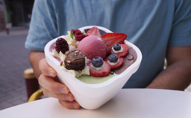Gourmet ice cream. Closeup view of a man holding an ice cream pot with beautiful decoration