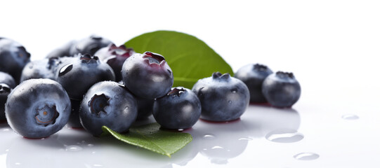 Long banner with pile of ripe fresh blueberries with blueberry leaves on isolated white background. Organic farm food, fresh market, healthy products.