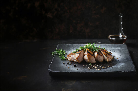 Gustoso petto di pollo arrosto con condimento di aceto balsamico e origano su piatto di ardesia