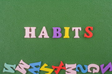 HABITS word on green background composed from colorful abc alphabet block wooden letters, copy...
