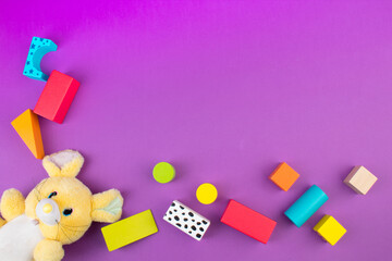 Top view of colorful wooden bricks on the table. Early learning. Educational toys on a purple...