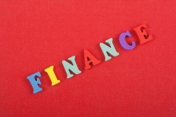 FINANCE word on red background composed from colorful abc alphabet block wooden letters, copy space...