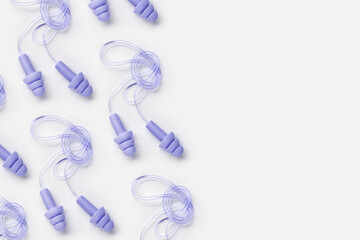 Creative flat lay pattern made purple silicone earplugs for swim, sleep, rest on white background....