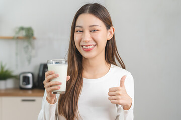 Health care, smile asian young woman, girl showing thumb up, holding glass of fresh, dairy soy milk...