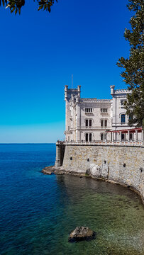 Scenic view of majestic historic white Miramare castle in Trieste in Friuli-Venezia Giulia, Italy, Europe. Blue sky in tranquil atmosphere at Adriatic Mediterranean sea in summer. Sightseeing