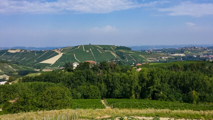 Fototapeta na wymiar Panoramic view of the famous vineyard during summer in Langhe wine region of Piedmont (Piemonte), Italy, Europe. Luxury couple get away vacation. Romantic tranquil atmosphere in rural area