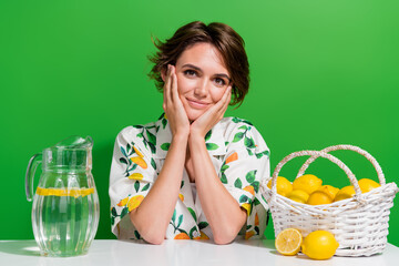 Photo of pretty cute young girl make her summer citrus lemonade glass jug collect basket organic lemons isolated on green color background - obrazy, fototapety, plakaty