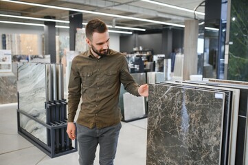 Male customer choosing kitchen ceramic tile in store