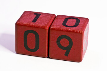 Number nine and ten written on a red wooden cube of a calendar date