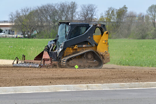 Track skid steer multi terrain loader landscaping an area for grass seeding