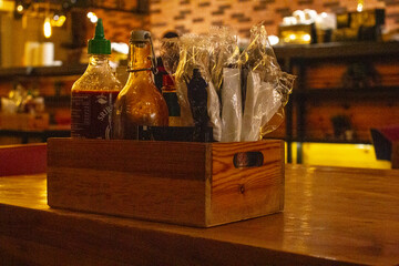 bottles of Sauce in a wooden basket