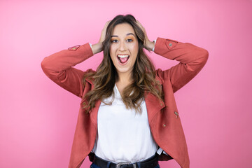 Young beautiful woman wearing casual jacket over isolated pink background afraid and shocked,...
