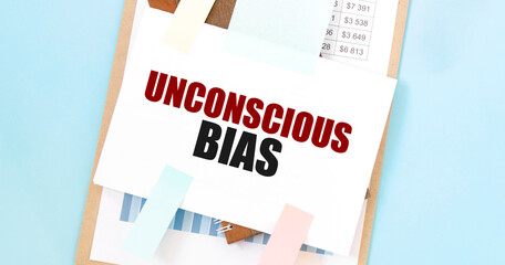 Unconscious Bias text on paper with colorful sticky notes and pencil on clipboard. Inclusive workplace and human resources concept - obrazy, fototapety, plakaty