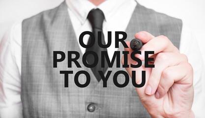Businessman writing OUR PROMISE TO YOU text. Customer service and commitment concept for design and...