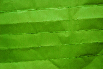 A sheet of folded green paper texture as background
