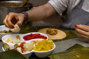 Preparation and ingredients of a Hallaca or tamale wrapped in banana leaf.