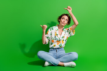 Full body photo of wearing shirt orange print denim jeans ponder lady looking directing fingers novelty isolated on green color background - obrazy, fototapety, plakaty