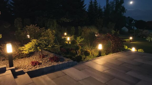 Beautiful Backyard Garden Illuminated with Lamps in the Evening
