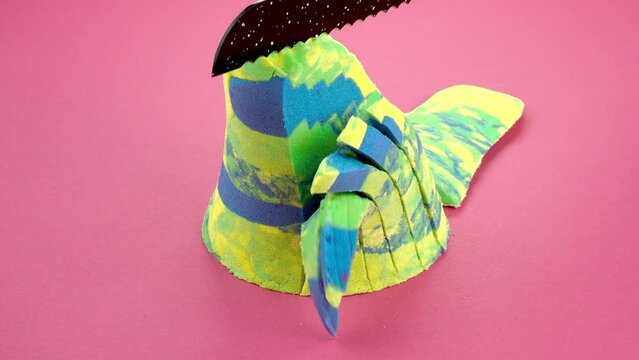 Very Satisfying and Relaxing Kinetic Sand ASMR. Cutting anti stress macro close up colorful Kinetic Sand with a Knife. Kinetic sand cutting with a knife on a black background. ASMR .