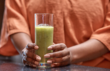 Hands, drink and woman with smoothie in home for healthy diet, nutrition or wellness at table in...