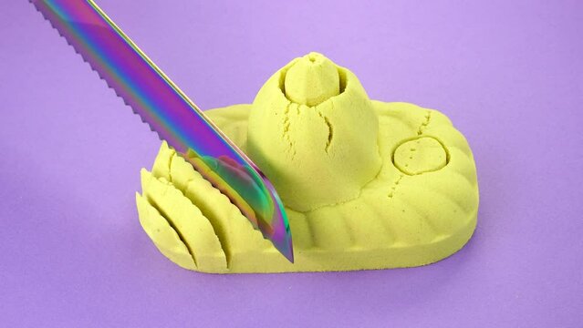 Very Satisfying and Relaxing Kinetic Sand ASMR. Cutting anti stress macro close up colorful Kinetic Sand with a Knife. Kinetic sand cutting with a knife on a black background. ASMR .