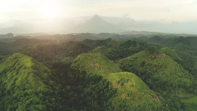 Aerial view of mountains sunset: Bohol Island, Chocolate Hills. Sun Asia tropical green hill with jungle at rural Mayon, Legazpi, Philippines. Philipino green grass valley. Nobody nature summer day