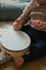 Bébé qui joue du tambour dans une chambre Montessori