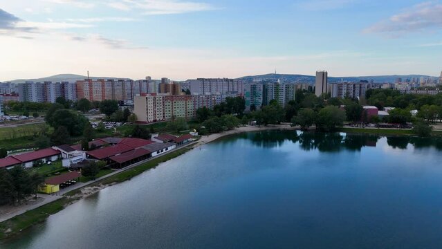 Discover urban tranquility with drone footage capturing a serene lake amidst city skyscrapers. Petržalka Draždiak Bratislava