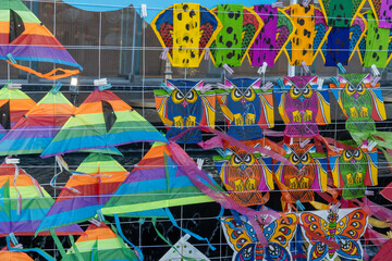 The shop arranges small kites in the shapes of various animals for customers.