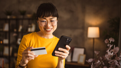 Japanese woman buy online with mobile phone and credit card at home