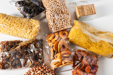 food storage, healthy eating and diet concept - close up of bags with dried fruits, cereals, pasta...