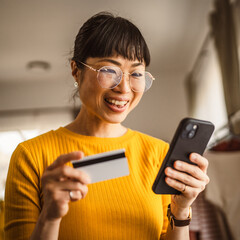 Japanese woman buy online with mobile phone and credit card at home