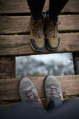 A couple takes a photograph of their hiking boots on a bridge on the Los Puentes Saja-Besaya route...