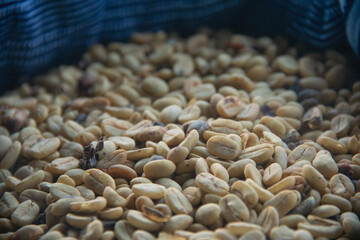 A close-up of many coffee green seeds in a blue wool bag