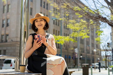 街角でスマホを見る50代女性