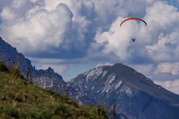 Paragliders Above Stubai Valley Against Cloudy Blue Sky