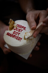 newlyweds eating a stylish wedding cake with an interesting inscription in the center of the cake