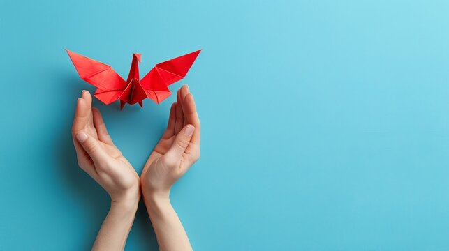   A woman's hands hold a red origami butterfly against a blue background ..Or, for a more compact version:..Woman'