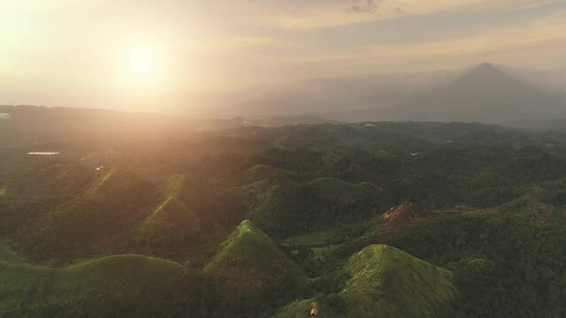 Aerial mountain sunset view: Bohol Island, Chocolate Hills. Sun Asia tropical green hill with jungle at rural Mayon, Legazpi, Philippines. Philipino green grass valley. Nobody nature summer day