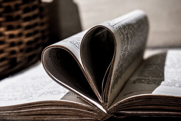 a thick book folded in the shape of a heart, an old stone in the shape of a love