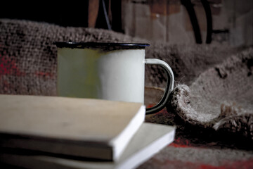 still life photography of enamel cup and thick book
