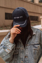 Street style cloth, woman wearing vintage denim jacket and blue cap with text New York