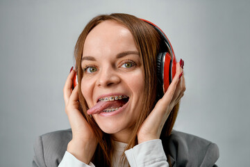 Young carefree woman with braces listening to playlist on headphones during lunch break